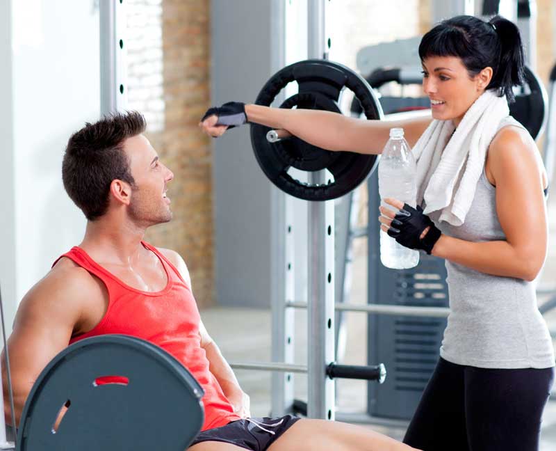 Girl Flirts with Guy next to Weight Rack